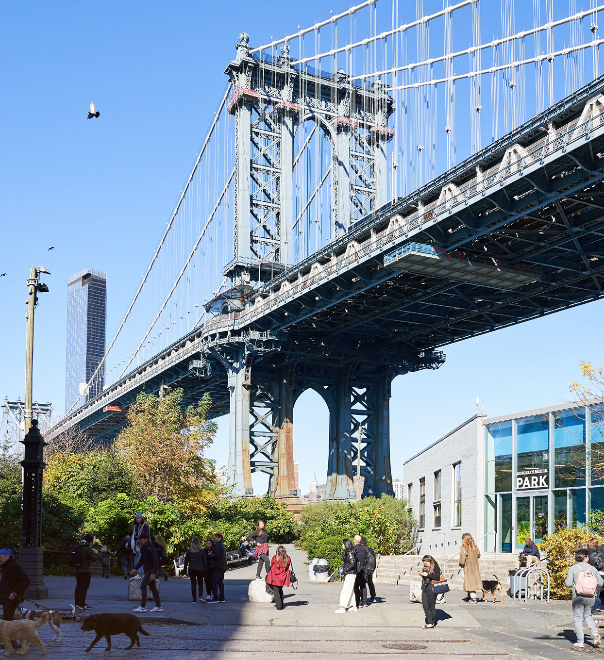 Brooklyn bridge in the daytime and people walking underneath