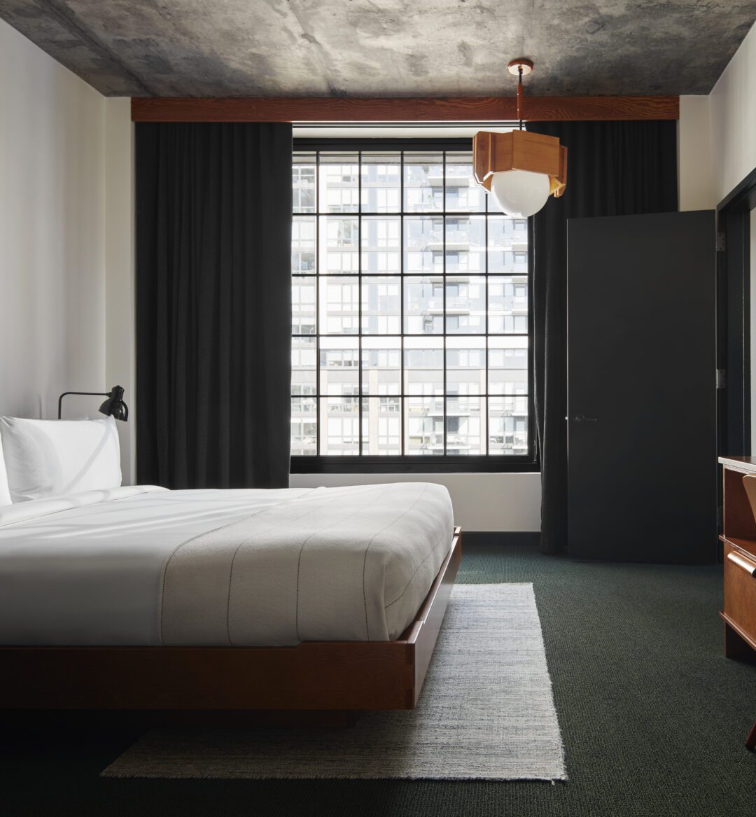 A dedicated bedroom provides a desk for work and window with city views