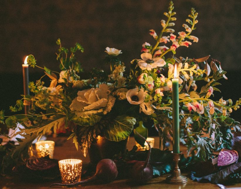 A flower bouquet and candles on the table