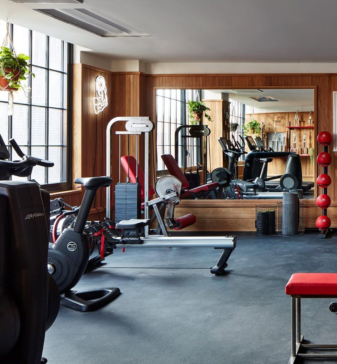 a photo of a gym with equipment that includes yoga mats, medicine balls, indoor row machine, upright bike and treadmills.