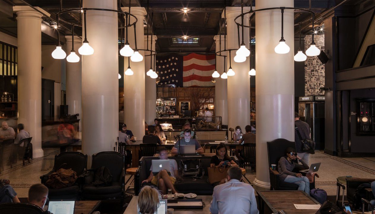 A lounge area full of people working on computers