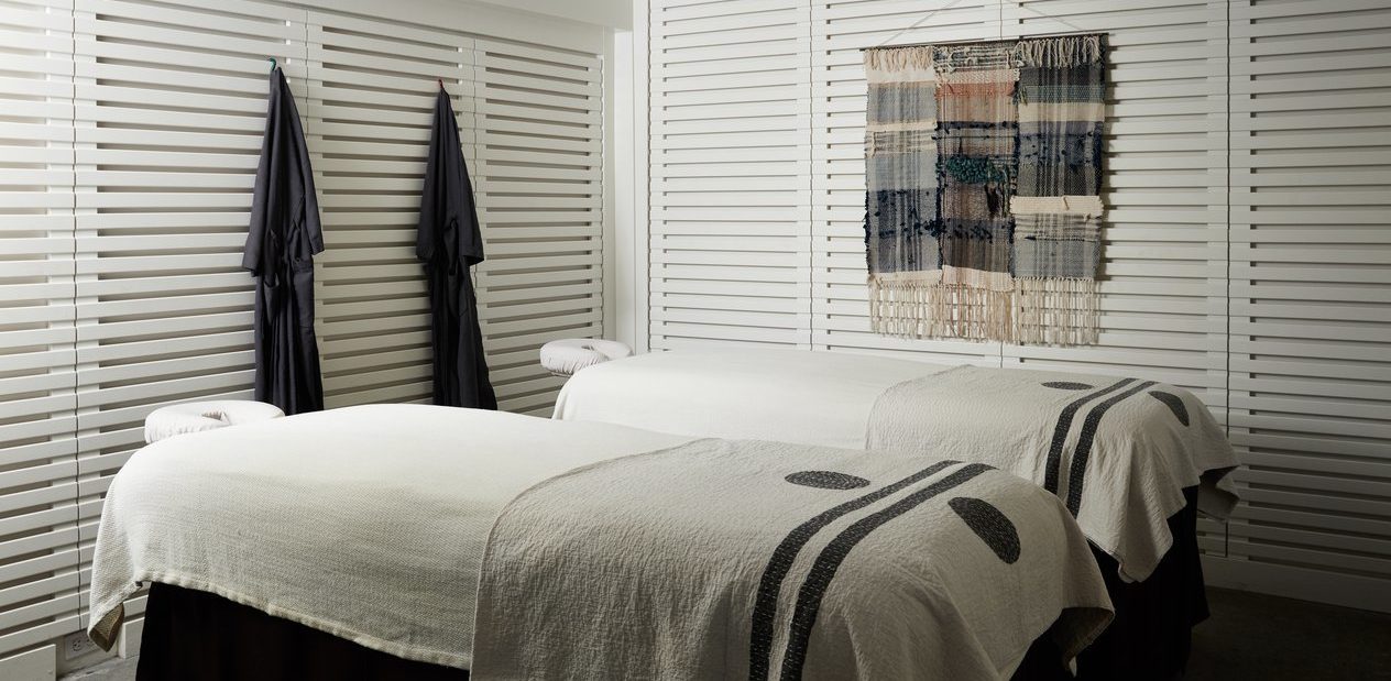 A spa room with two massage tables