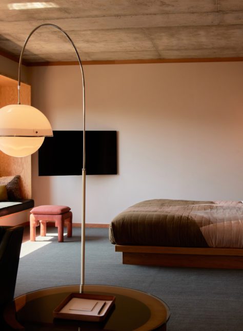 Modern furnishings adorn a living room looking into a bedroom; natural light floods the room