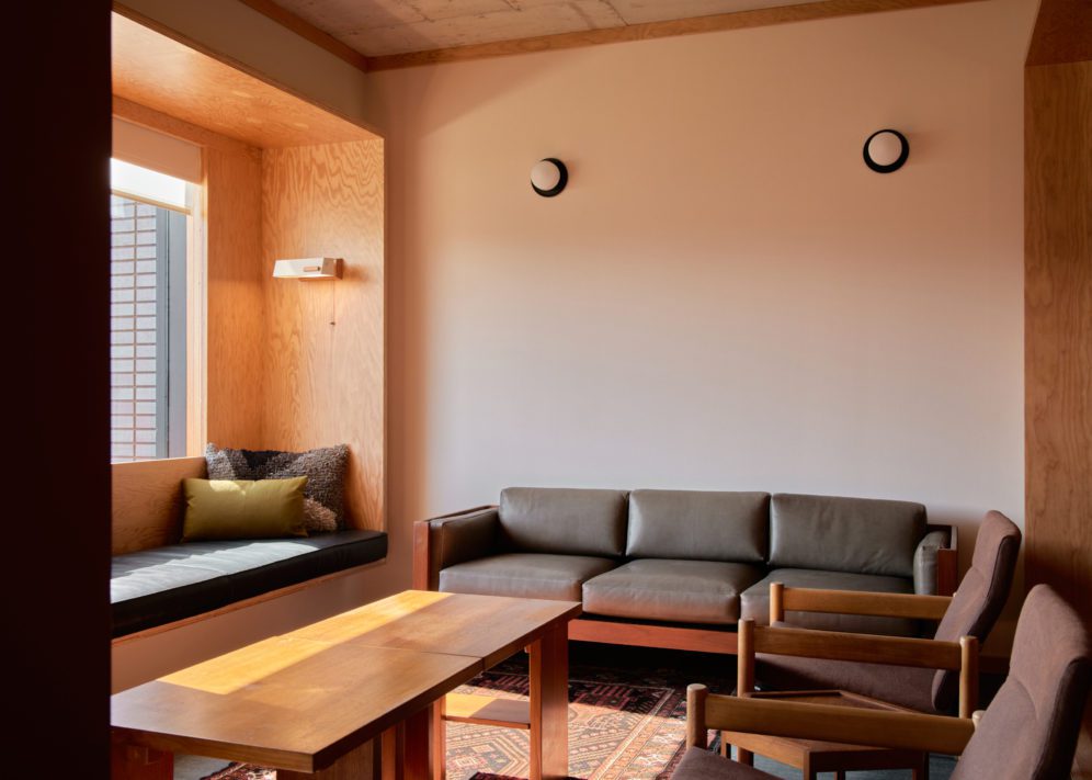 A modern black couch, black leather nook and two armchairs provide ample seating space